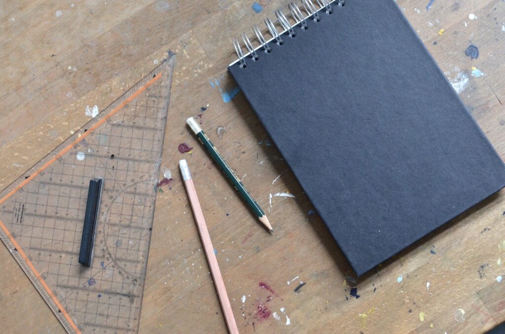 notebook with black sheets near stationery on table